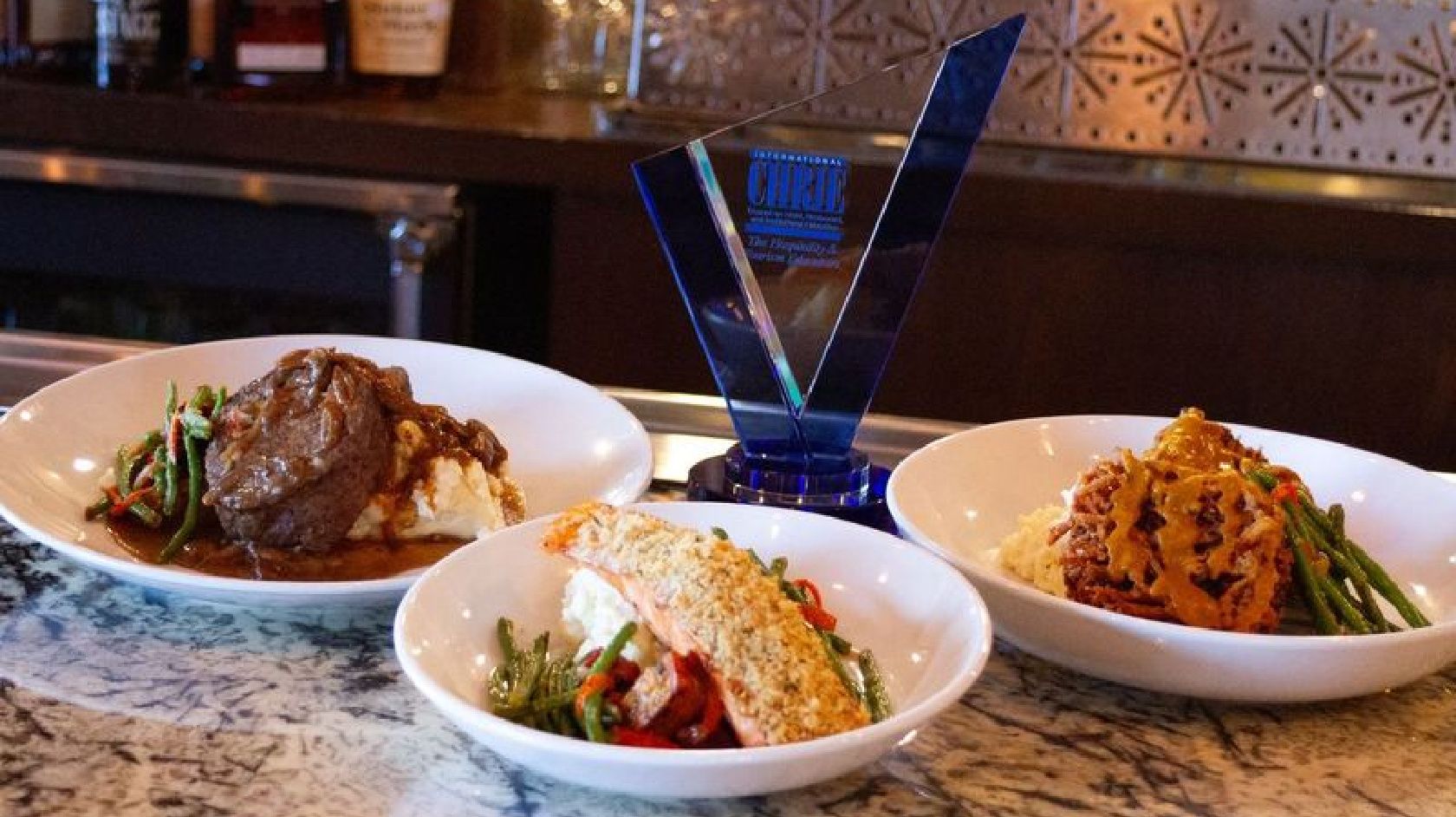 A Table With Plates Of Food And A Glass Of Water